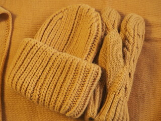 Fototapeta na wymiar a set of warm yellow clothes. hat mittens and scarf