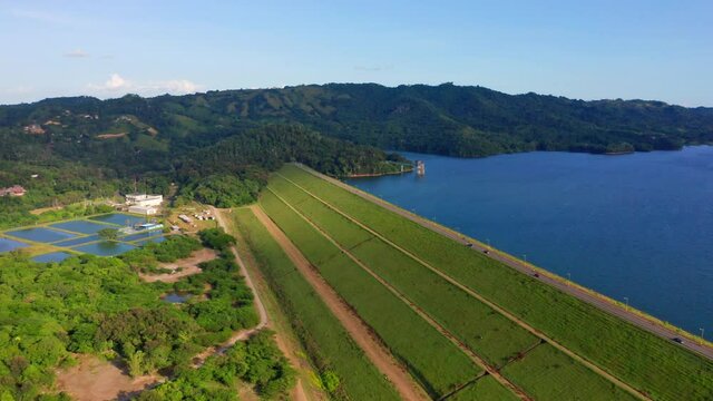 Green Fields And Lush Mountains Surrounding Hatillo Dam (Presa de Hatillo) In Dominican Republic - aerial drone shot