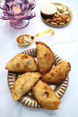 Indian Holi snack popuraly known as Gujia or Gujiya. Also called Karanji in Maharashtra, mostly eaten during Diwali. It is a deep fried sweet dish made from maida and stuffed with khoya or rava. copy.