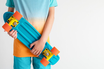 A skateboard for penny in the hands of a teenage boy on a white background. Blue and orange color.