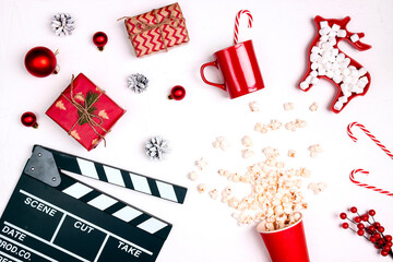 Fototapeta na wymiar Movie clapper board with Christmas decorations and gifts,popcorn, mug and marshmallow on white background.