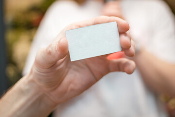 Hand holds a white piece of paper for notes