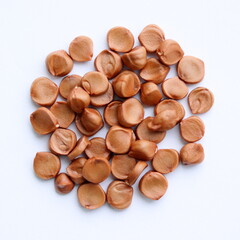 Yellow flag iris seeds isolated on white background. Iris pseudacorus. Top view.