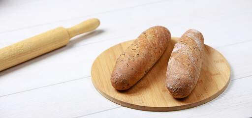 Bread on a cutting Board. Whole-grain rye bread. On light wooden table