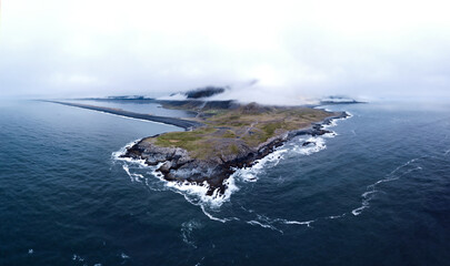 stunning coastal views in east iceland, aerial panorama of Eystrahorn with a black beach surrounded by the the blue atlantic ocean