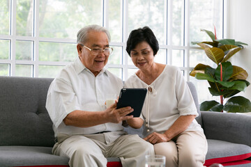 Happy senior people using digital tablet as a learning tool and spending time together, Asian Senior friends  at home.