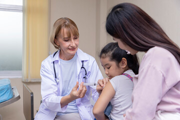 Pediatrician doctor doing vaccination of a little girl in hospital.