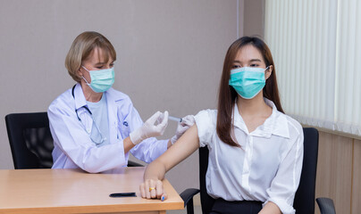Doctor woman injecting Covid-19 coronavirus vaccine to woman. Fight against Covid-19 coronavirus...