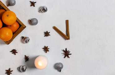 New Year's composition in the form of a clock. Christmas decorations on a white background. Oranges in a drawer, star anise, cinnamon sticks, candle. Flat lay, top view, copy space