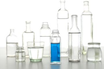 色の付いた水が入った瓶やコップ