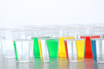 色の付いた水が入った瓶やコップ