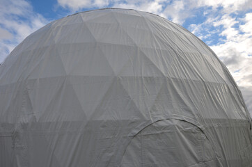 tent with hemispherical structure with triangle support frame. The white plastic is made of white plastic tarpaulin. The casing has holes for entry inside. research facility with its own atmosphere