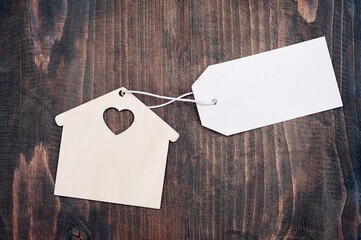 Miniature  house with blank sign on wooden background