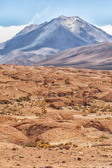 Bolivia, Atacama Desert. An active volcano rises above an old lava field.