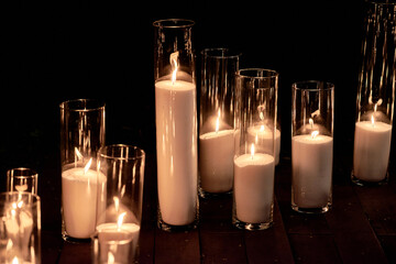 Night wedding ceremony decorations with candles in glass vases outdoors, copy space