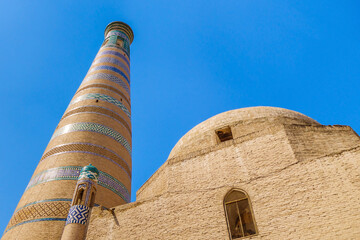 Minaret Islam Khoja next to the madrasah of the same name against the blue sky. It is the second...
