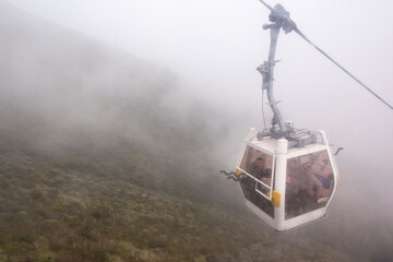 Fototapeta premium Ecuador, Quito. TeleferiQo cable car in clouds. Rises to 13,000 ft, one of highest in world. Bikers have option to ride back down
