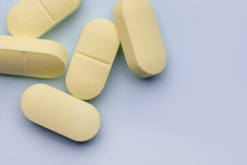 Several yellow pills on a gray background. Pharmacy. Medicines. Studio shot, copy space.