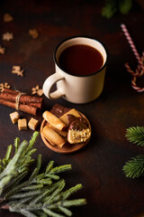 mug of hot chocolate surrounded by Christmas decorations