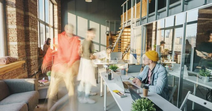 Time lapse of active young men and women colleagues busy with job in sunlit coworking space. Modern business locations and cooperation concept.