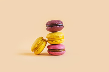 Tasty french macarons on a yellow pastel background.