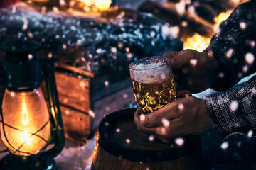 Man with glass of beer at winter night