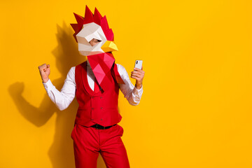 Photo of influencer guy hold telephone rejoice hundred likes wear cock mask red suit isolated yellow color background - obrazy, fototapety, plakaty