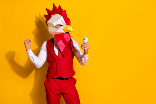 Photo of influencer guy hold telephone rejoice hundred likes wear cock mask red suit isolated yellow color background