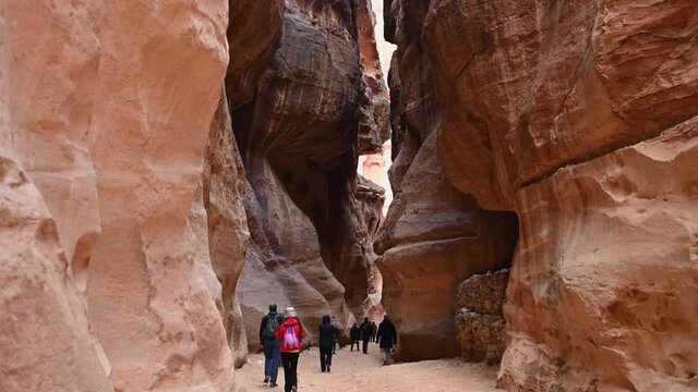 Stunning view of some tourists walking and taking pictures at Al-Khazneh (The treasury) Petra, Jordan.