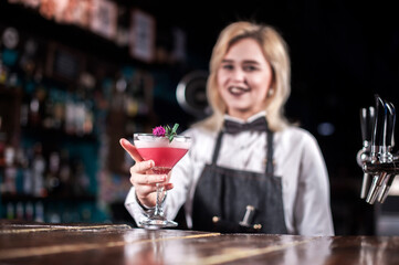 Confident woman bartender makes a show creating a cocktail in the pub
