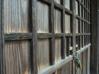 南京錠の掛かる神社の倉庫の木戸