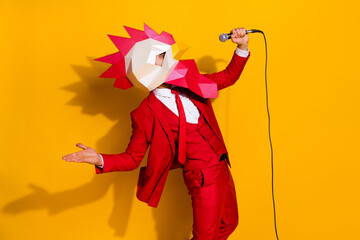 Photo of funny wacky guy sing mardi song performance wear rooster mask red tux isolated yellow...