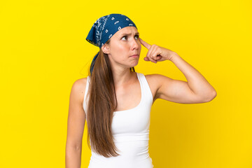 Naklejka premium Young English woman isolated on yellow background making the gesture of madness putting finger on the head