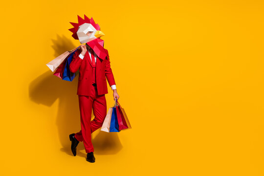 Photo of confident cocky client hold outfit packages wear chicken mask red tux isolated yellow color background