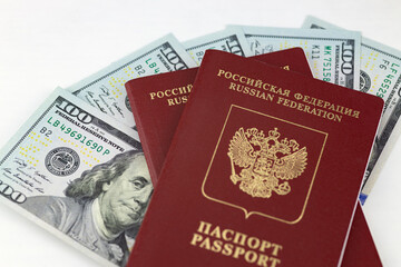 Russian international passports are on American dollars, 100 dollar bills. White background.