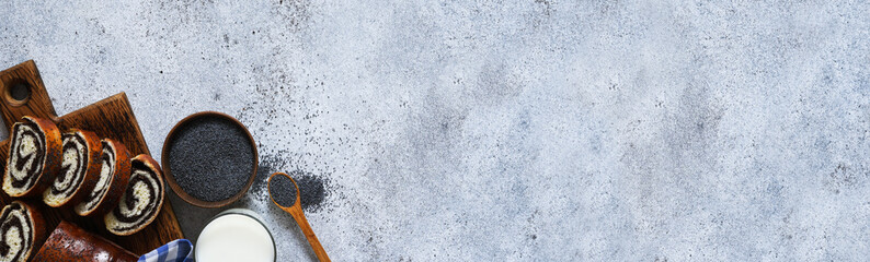 Pie with poppy seeds and milk. Roll on a wooden board top view.