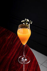 Bellini low abv cocktail in a flute glass garnished with flowers
