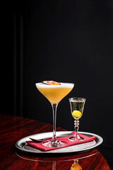 Pornstar martini cocktail with passion fruit and vodka, served with sparkling wine in a separate glass on a silver tray - 472783985