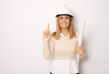 Young smiling woman architect pointing finger up isolated on white background.