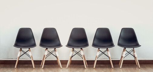 Row of chairs on wooden floor against white wall background. Vintage style. concept for business in...