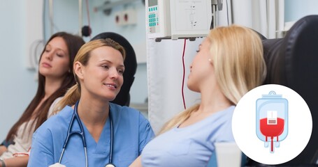 Fototapeta premium Smiling doctor looking donor sitting on chair during blood donation at hospital
