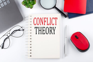 CONFLICT THEORY text on a notepad with laptop on the white background