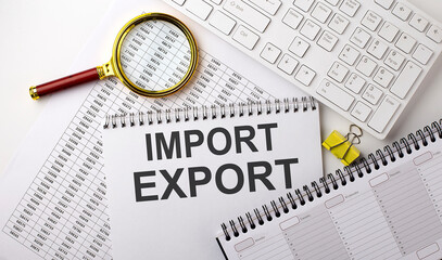 IMPORT EXPORT text written on a notebook on chart with keyboard and planning