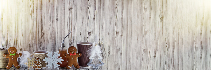 Bulb and cardboard cup, gingerbread cookies, Christmas decorations. Wooden and crafting organic Christmas background design with copy space. Aesthetic cozy home or office place. Extra wide banner