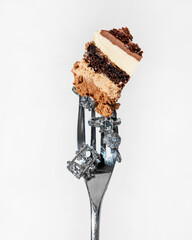 A piece of dessert cake Three chocolates on a fork decorated with rings