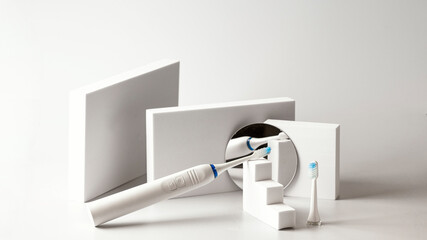 Dental care still life banner. Electric toothbrush and clear replacement on blue background with...