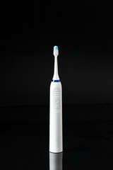 Modern ultrasonic toothbrush on black reflection background. Advertisement example brand image