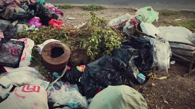 Astrakhan, Russia - circa august 2021: Garbage covering about trash bins in undeveloped district.
