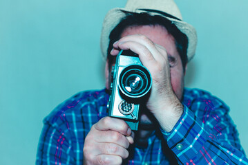 Man with Camera.cameraman make film on a retro camera.man with a plaid shirt filming with a Super 8...