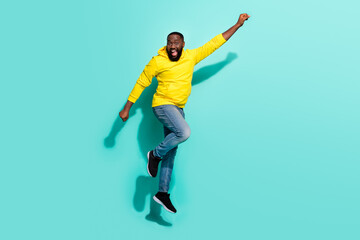 Fototapeta na wymiar Full size photo of crazy guy jump raise hand up forward rush bargains isolated over cyan color background